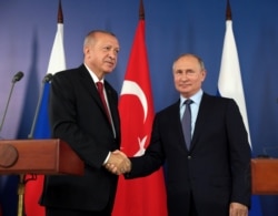 FILE - Russian President Vladimir Putin, right, and his Turkish counterpart Recep Tayyip Erdogan shake hands during a joint news conference in Zhukovsky outside Moscow, Russia, Aug. 27, 2019.