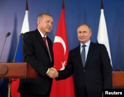 FILE - Russian President Vladimir Putin, right, and his Turkish counterpart Recep Tayyip Erdogan shake hands during a joint news conference in Zhukovsky outside Moscow, Russia, Aug. 27, 2019.