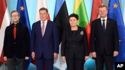 Estonian Ambassador to Poland Harri Tiido, left, and Prime Ministers from Latvia Maris Kucinskis, second left , Poland Beata Szydlo and Lithuania Saulius Skvernelis, right, pose for a photo prior to talks in Warsaw, Poland, Sept. 5, 2017.