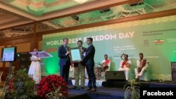 အီသီယိုပီးယားႏိုင္ငံမွာ က်င္းပတဲ့ ကမၻာ့သတင္းလြတ္လပ္ခြင့္ညီလာခံမွာ UNESCO ကခ်ီးျမွင့္တဲ့ ၂၀၁၉ခုႏွစ္ Guillermo Cano ကမၻာ့သတင္းလြတ္လပ္ခြင့္ဆုကို ကို၀လံုးနဲ႕ ကိုေက်ာ္စိုးဦးကိုယ္စား လက္ခံရယူေနတဲ့ ကို၀လံုးညီျဖစ္သူ ကိုသူရေအာင္