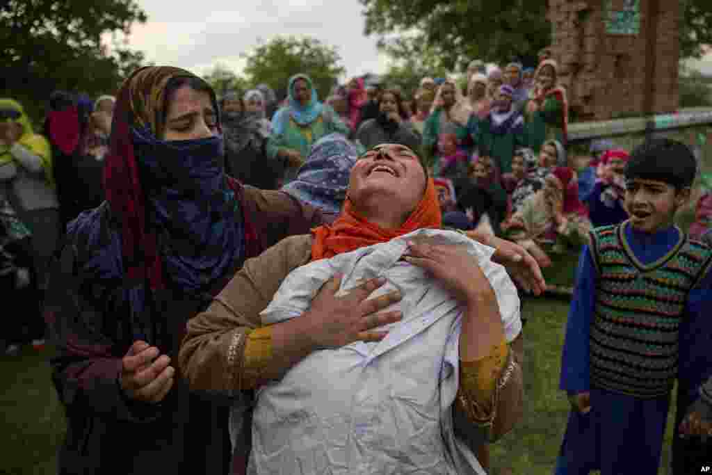 인도령 카슈미르주 스리나가르 남부에서 52km 떨어진 핀주라 마을에서 시위 중 사망한 남성의 장례식이 열린 가운데, 동생이 숨진 남성의 셔츠를 끌어안은 채 울고 있다.