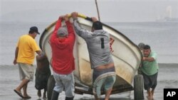 Fishermen pull a boat from the sea in preparation for a possible tsunami in the Pacific resort city of Mazatlan, Mexico, March 11, 2011