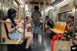 Warga mengenakan masker di kereta bawah tanah (subway) di New York City (foto: dok).