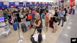 Delta Air Lines passengers stand in line after flights resumed Aug. 8, 2016, in Salt Lake City, following a computer outage.