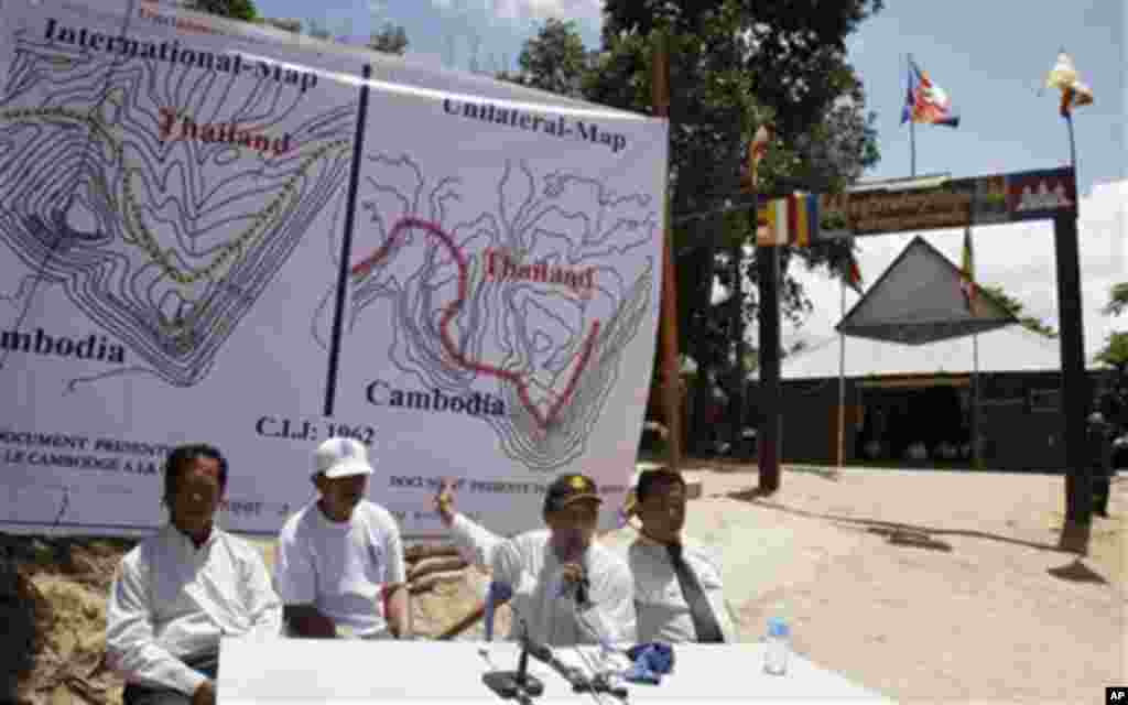 Cambodia Council of Ministers spokesman Phay Siphan, second right, points to maps during a press conference in front of the Wat Keo Sikha Kirisvara Buddhist pagoda near Cambodia's 11th century Hindu Preah Vihear temple in Preah Vihear province. Shooting b