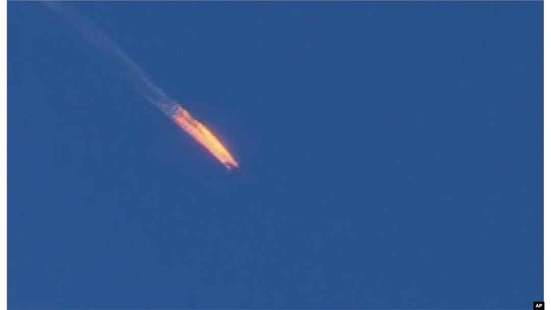 FILE - This frame grab from video by Haberturk TV, shows a Russian warplane on fire before crashing on a hill as seen from Hatay province, Turkey, Nov. 24, 2015.