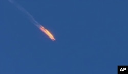 FILE - This frame grab from video by Haberturk TV, shows a Russian warplane on fire before crashing on a hill as seen from Hatay province, Turkey, Tuesday, Nov. 24, 2015.