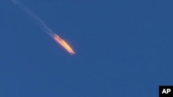 This frame grab from video by Haberturk TV, shows a Russian warplane on fire before crashing on a hill as seen from Hatay province, Turkey, Tuesday, Nov. 24, 2015.