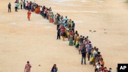 Hundreds of people line up to receive their second dose of vaccine against the coronavirus at the municipal ground in Hyderabad, India, Thursday, July 29, 2021.