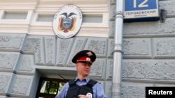 A Russian policeman stands outside the embassy of Ecuador in Moscow, June 24, 2013.
