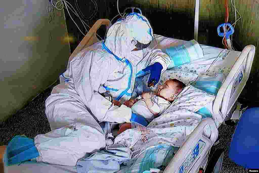 A nurse comforts a seven-month-old baby after an operation at the Salesi Hospital in Ancona, Italy. The baby's parents are not able to visit him due to COVID-19 restirictions. (Ospedali Riuniti Marche/Handout)