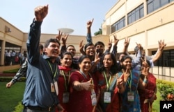 FILE - Indian Space Research Organisation scientists and officials pose for photos as they celebrate the success of Mars Orbiter Mission at their Telemetry, Tracking and Command Network complex in Bangalore, India, Sept. 24, 2014.
