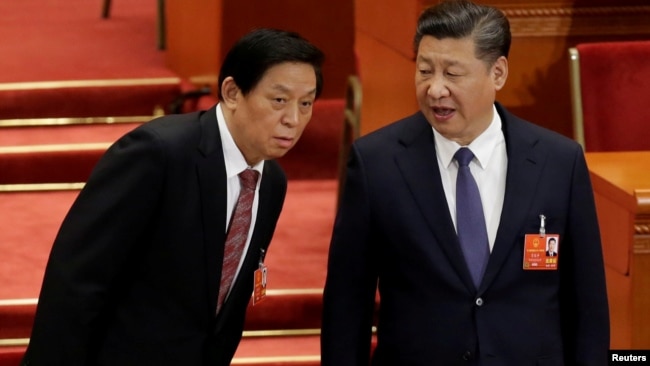 中国领导人习近平和中共中央政治局常委、全国人大委员长栗战书2018年3月11日在北京人大会堂举行的全国人大会议上交谈。