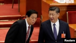 中国领导人习近平和中共中央政治局常委栗战书2018年3月11日在北京人大会堂举行的全国人大会议上交谈。