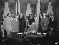 FILE - President Harry S. Truman signs a proclamation declaring into effect the 12-nation Atlantic Pact binding North America and Western Europe in a common defense alliance, Aug, 24, 1949. Witnessing the signing (L-R): Hoyar Miller of the United Kingdom; Ambassador Henrik De Kauffmann of Denmark; Canadian Embassy Counselor W.D. Matthews; Secretary of Defense Louis Johnson; Ambassador Wilhelm Munthe De Morgenstierne of Norway; Ambassador Henri Bonnet of France; Baron Silvercruys, Ambassador of Belgium, Ambassador Pedro Pereira of Portugal; Secretary of State Dean Acheson; Netherlands Minister Jonkheer O. Reuchlin, and Italian Embassy Counselor Mario Lucioli.