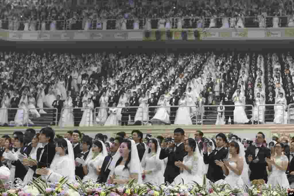 مراسم جمعی ازدواج در کره جنوبی با حضور زوج هایی از سراسر جهان و کره در سالن صلح جهانی. آنها در مراسم عروسی دسته جمعی کلیسای وحدت شرکت کردند.