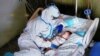 A nurse comforts a seven-month-old baby after an operation at the Salesi Hospital in Ancona, Italy. The baby&#39;s parents are not able to visit him&nbsp;due to COVID-19 restirictions. (Ospedali Riuniti Marche/Handout)