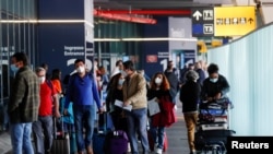 Los viajeros caminan por el aeropuerto Fiumicino en Italia, después de que este país levantara las restricciones por la pandemia de coronavirus en mayo de 2021.