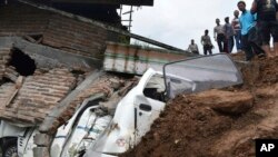 Regu penyelamat memeriksa kerusakan akibat tanahh longsor di kawasan desa Banaran, Ponorogo, Jawa Timur, 1 April 2017. (Foto:AP/Firdaus) 