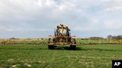 Petani Rick Clifton mengendarai traktor di salah satu ladangnya, menyemprotkan herbisida untuk melindungi tanamannya selama musim gugur dan musim dingin di Orient, Ohio, 5 April 2021. (AP Photo/John Flesher)