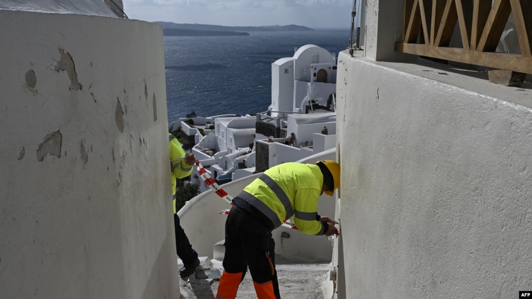 Municipal employees place caution tape to restrict access for tourists due to recent seismic activities in Oia village on the Greek island of Santorini, Feb. 5, 2025. 