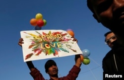 FILE - A participant holds a placard during Delhi Queer Pride Parade, an event promoting gay, lesbian, bisexual and transgender rights in New Delhi, Nov. 30, 2014.