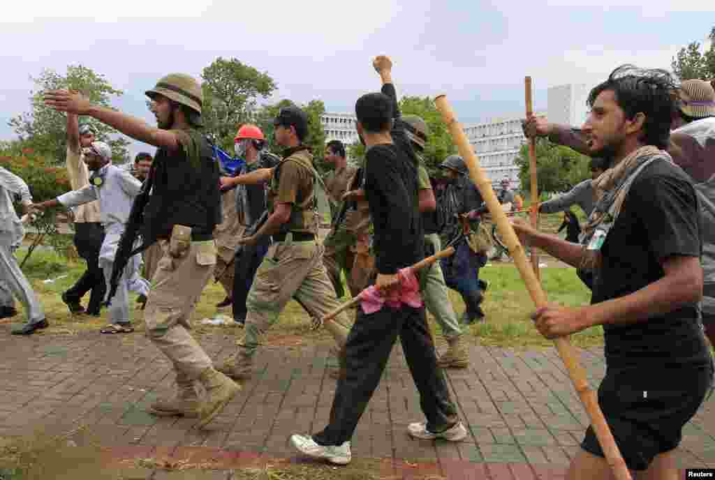 Demonstrators chant while walking with soldiers from the Pakistan Rangers, Islamabad, Sept. 1, 2014.