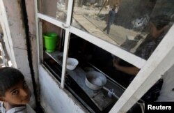 An Iraqi man is seen reflected in a cafe window in the destroyed Old City of Mosul, Iraq, Aug. 7, 2017.
