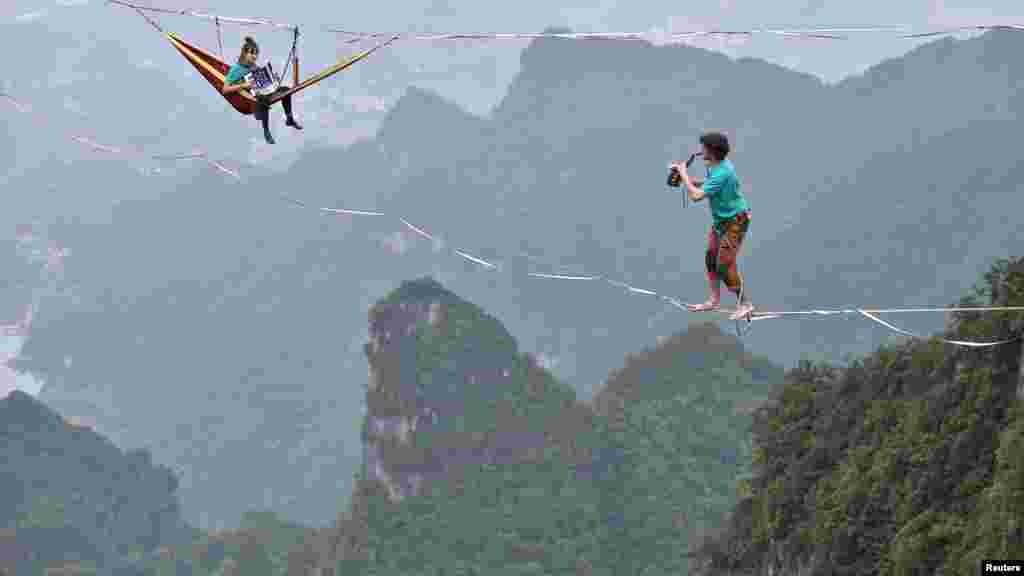 Members of performing group Houle Douce practise their instruments on tightropes ahead of a performance, at the Tianmen Mountain National Park in Zhangjiajie, Hunan province, China.