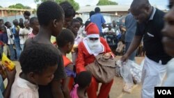 Santa Claus shares sweets and other gifts with students at the Jacaranda School for Orphans (VOA/L. Masina)