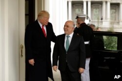 President Donald Trump, left, greets Iraqi Prime Minister Haider al-Abadi upon his arrival to the White House in Washington, March 20, 2017.