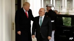 President Donald Trump, left, greets Iraqi Prime Minister Haider al-Abadi upon his arrival to the White House in Washington, March 20, 2017.