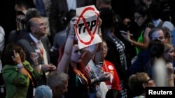 Seorang delegasi mengangkat poster anti-Trans-Pacific Partnership (TPP) di Konvensi Nasional Partai Demokrat Senin (25/7).