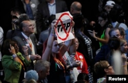 FILE - A delegate holds an anti-Trans-Pacific Partnership (TPP) trade agreement sign during the first day of the Democratic National Convention in Philadelphia, July 25, 2016.