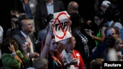 FILE - A Democratic National Convention delegate holds a sign opposing the proposed Trans-Pacific Partnership (TPP) trade deal, in Philadelphia, Pa., July 25, 2016. 