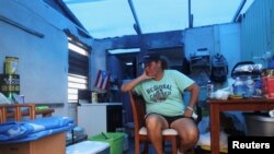 FILE - Jazmin Morales sits in her kitchen without power and with a plastic sheet replacing the roof after Hurricane Maria hit the island in September, in Yabucoa, Puerto Rico January 29, 2018. 