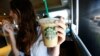 Seorang pelanggan mengangkat minuman dingin di kedai kopi Starbucks di Pasadena, California, 25 Juli 2013 (foto: Reuters/Mario Anzuoni)