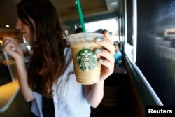 FILE - A patron holds an iced beverage at a Starbucks coffee store in Pasadena, Calif., July 25, 2013. Straws and stirrers are among the top 10 items found in coastal trash cleanups.