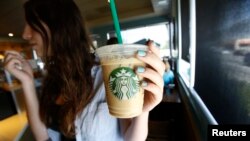 Seorang pelanggan mengangkat minuman dingin di kedai kopi Starbucks di Pasadena, California, 25 Juli 2013 (foto: Reuters/Mario Anzuoni)