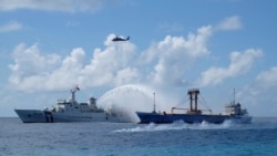 FILE - A Taiwan Coast Guard ship, left, and cargo ship take part in a search-and-rescue exercise off of Taiping island in the South China Sea, Nov. 29, 2016.