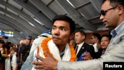 Nima Rinji Sherpa, who claims the record for youngest person to scale world's 14 highest peaks, is welcomed upon his arrival at the airport during a welcoming ceremony in Kathmandu, Nepal, Oct. 14, 2024. 