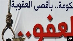 A man looks at a billboard in Muharraq demanding no leniency for those who opposed the Bahraini regime, April 28 2011