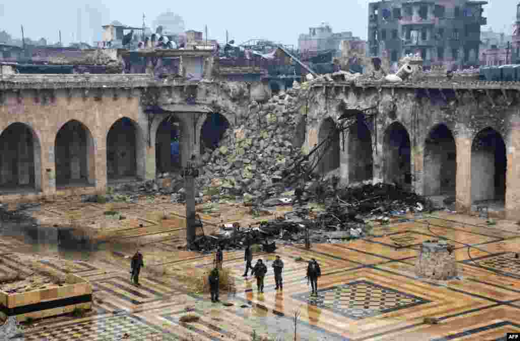 A general view shows Syrian pro-government forces walking in the ancient Umayyad mosque in the old city of Aleppo after they captured the area.