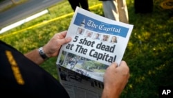 Steve Schuh, county executive of Anne Arundel County, holds a copy of The Capital Gazette near the scene of a shooting at the newspaper's office in Annapolis, Maryland. (AP Photo/Patrick Semansky)