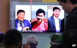People watch a TV news report showing portraits of three Americans, Kim Dong Chul, left, Tony Kim, center, and Kim Hak Song, detained in North Korea, at the Seoul Railway Station in Seoul, South Korea, May 3, 2018.