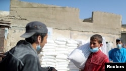 Seorang pekerja Palestina membawa sekarung gandum yang dikelola United Nations Relief and Works Agency (UNRWA), untuk dibagikan kepada pengungsi Palestina di Gaza City (foto: dok). 