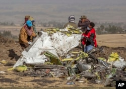 FILE - In this file photo dated Monday, March 11, 2019, rescuers work at the scene of an Ethiopian Airlines' Boeing 737 MAX plane crash south of Addis Ababa, Ethiopia. (AP Photo/Mulugeta Ayene, FILE)