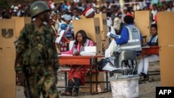 FILE: A Malawian army soldier stands guard while hundreds of residents from Ndirande township queue to vote as voting procedures are repeated after polling were disrupted yesterday, on May 21, 2014 in Blantyre.
