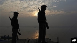 Indian police officers stand guard near the site of Tuesday's blast on the banks of the River Ganges in Varanasi, India, 08 Dec 2010