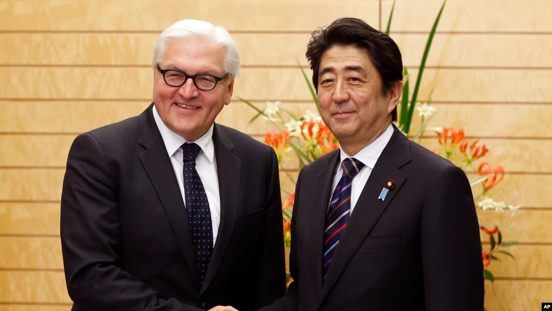Menlu Jerman Frank-Walter Steinmeier (kiri) berpose dengan PM Jepang Shinzo Abe seusai rapat di Tokyo (11/4).